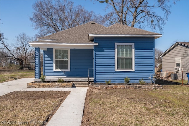 view of front of house featuring roof with shingles and a front lawn