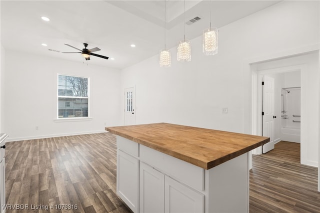 kitchen with pendant lighting, dark wood-style flooring, visible vents, wooden counters, and white cabinets