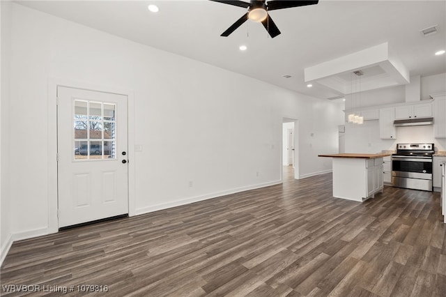 kitchen featuring under cabinet range hood, dark wood-style floors, wood counters, open floor plan, and stainless steel electric range oven