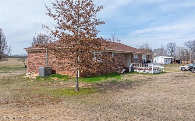 exterior space with a wooden deck, a yard, and central AC unit