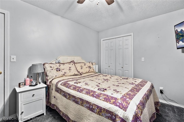 bedroom with ceiling fan, dark carpet, a textured ceiling, and a closet