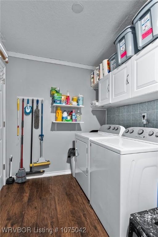 laundry area featuring washer and clothes dryer, cabinets, dark hardwood / wood-style floors, and ornamental molding