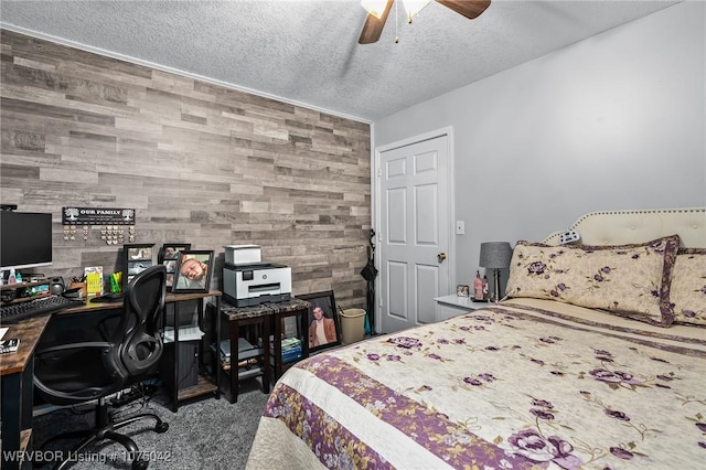 bedroom with carpet, ceiling fan, wood walls, and a textured ceiling