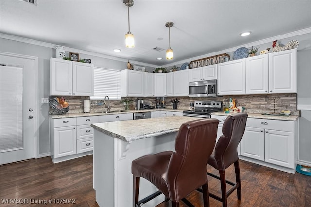 kitchen with white cabinetry, sink, pendant lighting, and appliances with stainless steel finishes