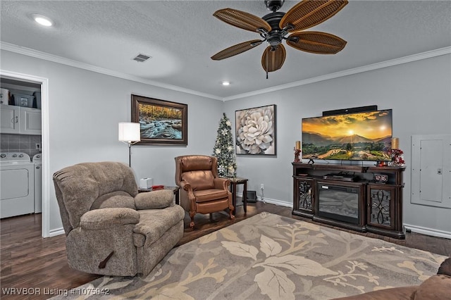 living area with a textured ceiling, washing machine and dryer, dark wood-type flooring, and crown molding