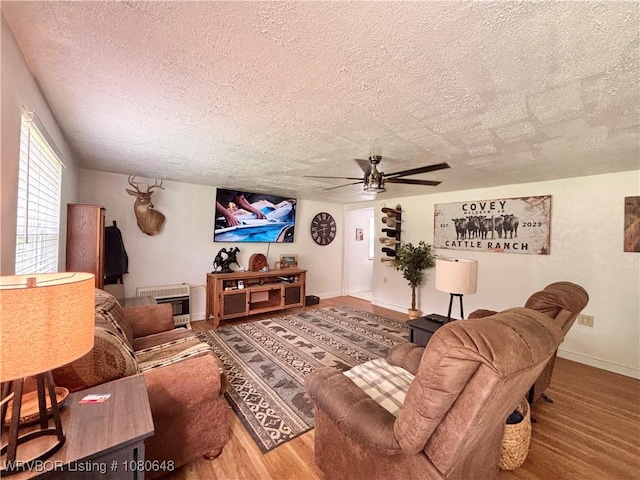 4245 W Piney Mountain Rd, Waldron, AR 72958 - living room with baseboards, a ceiling fan, a textured ceiling, and wood finished floors