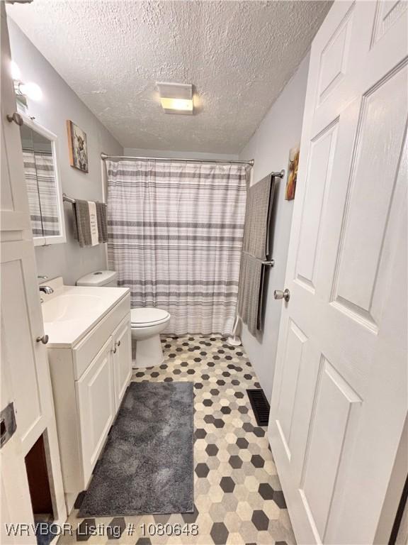 4245 W Piney Mountain Rd, Waldron, AR 72958 - bathroom featuring toilet, a textured ceiling, a shower with shower curtain, and vanity