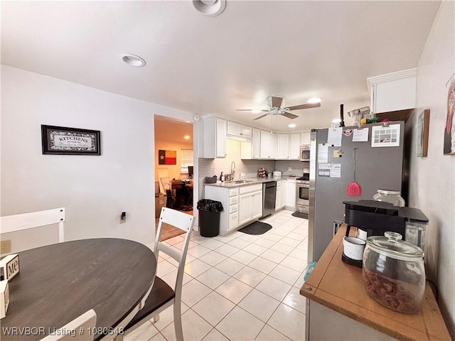 4245 W Piney Mountain Rd, Waldron, AR 72958 - kitchen with white cabinets, ceiling fan, appliances with stainless steel finishes, a sink, and light tile patterned floors