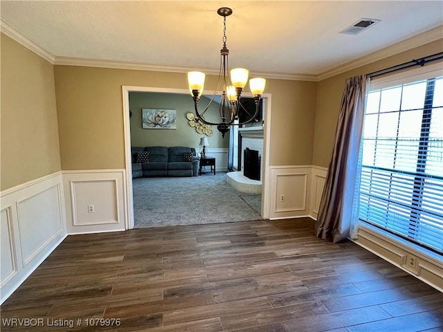 2205 Crosshill Rd, Fort Smith, AR 72908 - unfurnished dining area with a chandelier, crown molding, a wainscoted wall, dark wood-style flooring, and a decorative wall