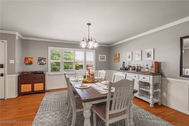 7118 S T St, Fort Smith, AR 72903 - dining room featuring ornamental molding, a chandelier, light wood-style floors, and a wainscoted wall