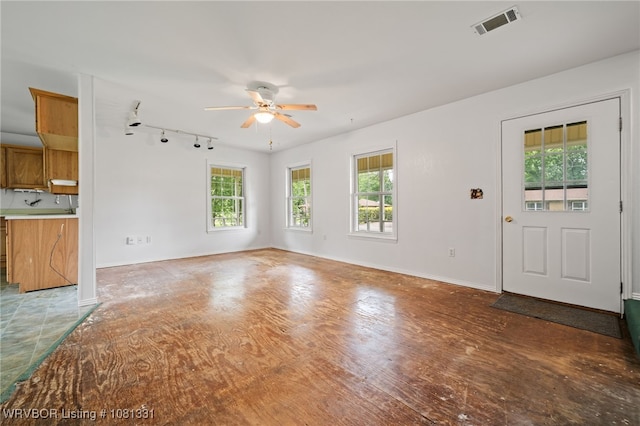 505 7th St, Barling, AR 72923 - unfurnished living room featuring ceiling fan, healthy amount of natural light, rail lighting, and baseboards