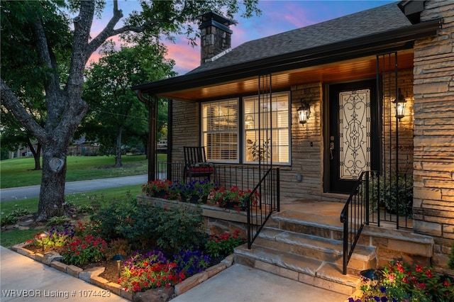 exterior entry at dusk with covered porch