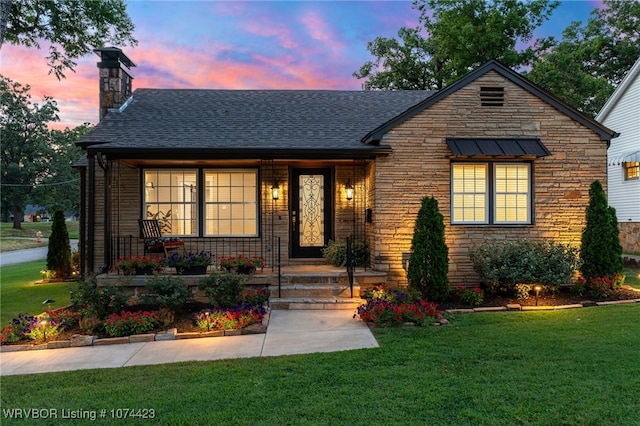 view of front of property featuring covered porch and a yard