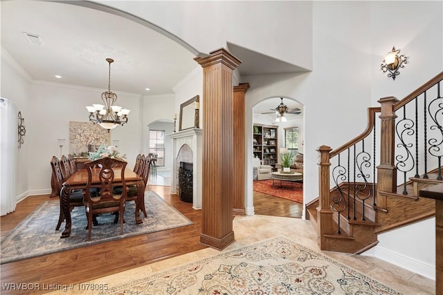 dining area with ceiling fan with notable chandelier, ornamental molding, and ornate columns