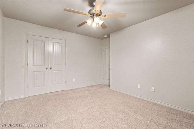 unfurnished bedroom with ceiling fan, a closet, and light colored carpet