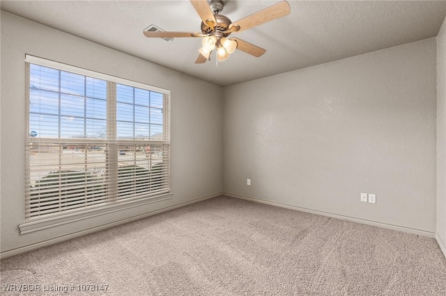 carpeted spare room featuring ceiling fan