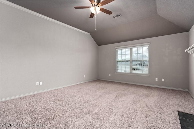 spare room with carpet, vaulted ceiling, ceiling fan, and ornamental molding