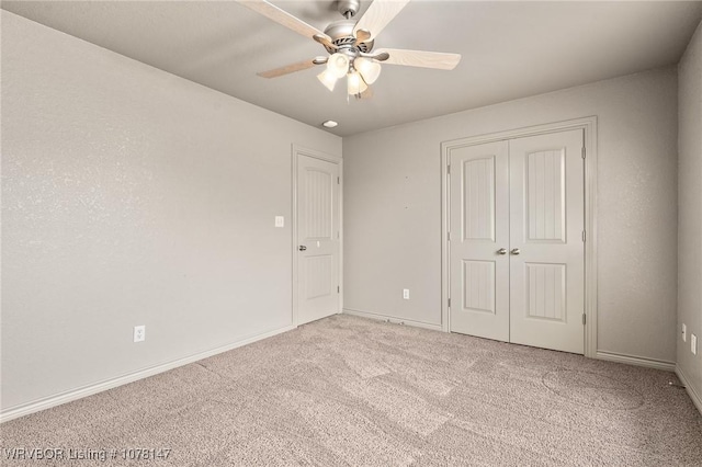 unfurnished bedroom with ceiling fan, light colored carpet, and a closet