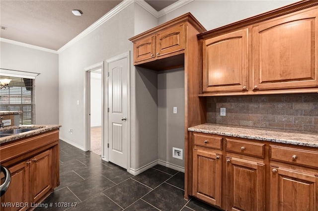 kitchen with sink, light stone counters, a notable chandelier, decorative backsplash, and ornamental molding