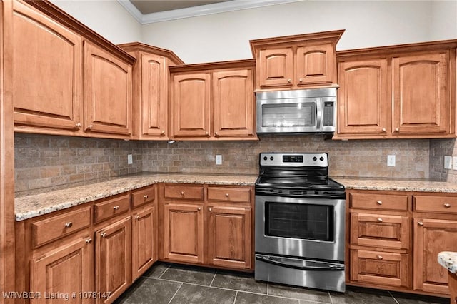 kitchen featuring light stone countertops, dark tile patterned floors, decorative backsplash, appliances with stainless steel finishes, and ornamental molding