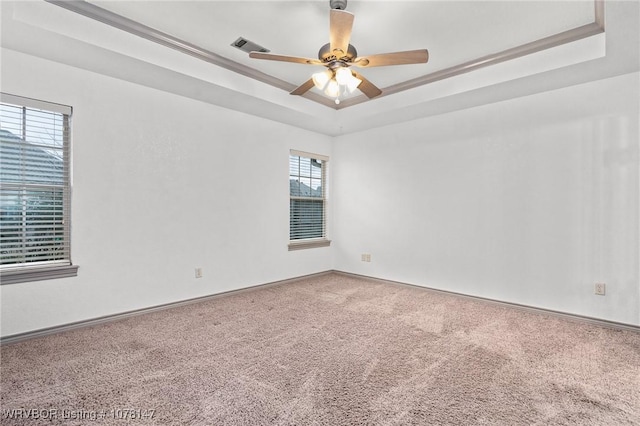 empty room featuring carpet flooring, a raised ceiling, and ceiling fan