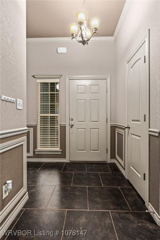 foyer entrance with a notable chandelier and ornamental molding