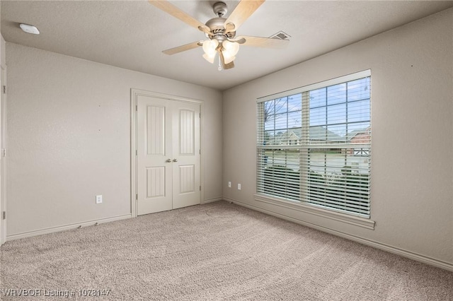 unfurnished bedroom featuring a closet, ceiling fan, and light colored carpet