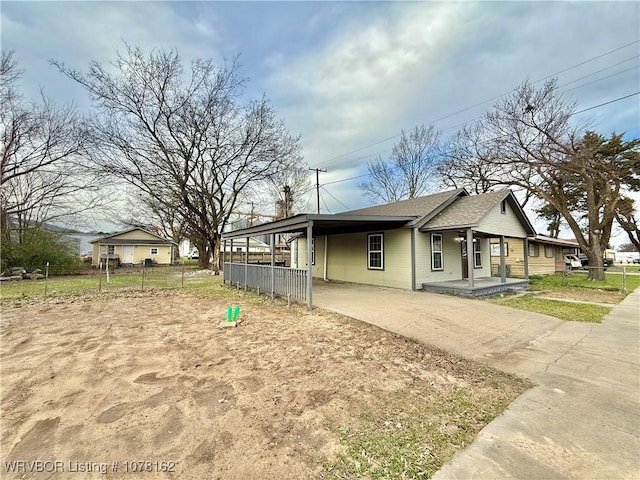 view of side of property featuring covered porch and a carport