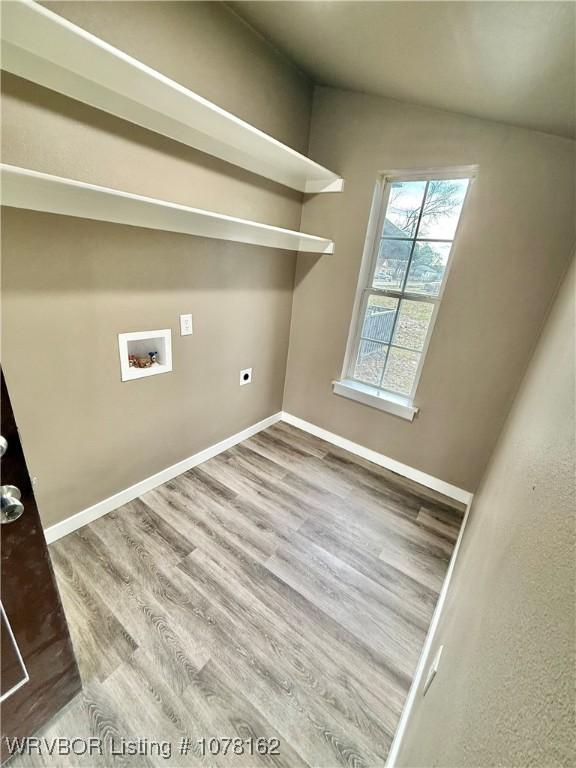 clothes washing area featuring hookup for an electric dryer, washer hookup, and hardwood / wood-style flooring