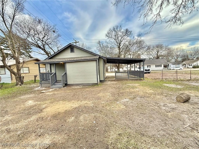 back of house featuring a carport