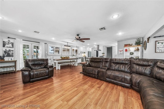 living room featuring ceiling fan, light hardwood / wood-style floors, and french doors