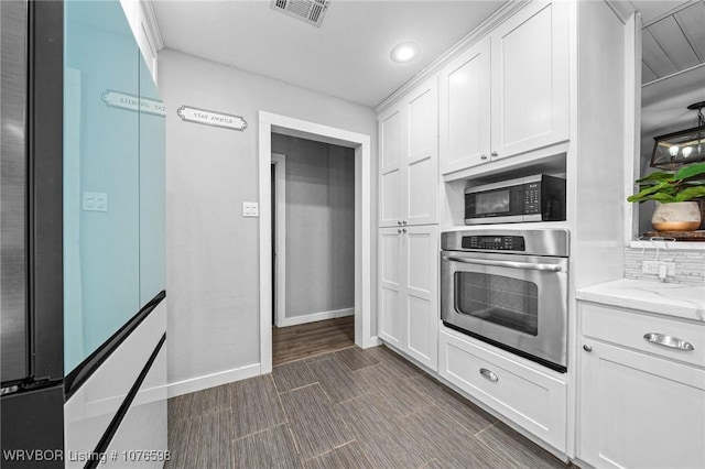 kitchen featuring decorative backsplash, light stone counters, white cabinetry, and stainless steel appliances