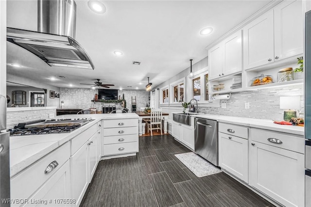 kitchen with sink, hanging light fixtures, ceiling fan, white cabinetry, and stainless steel appliances