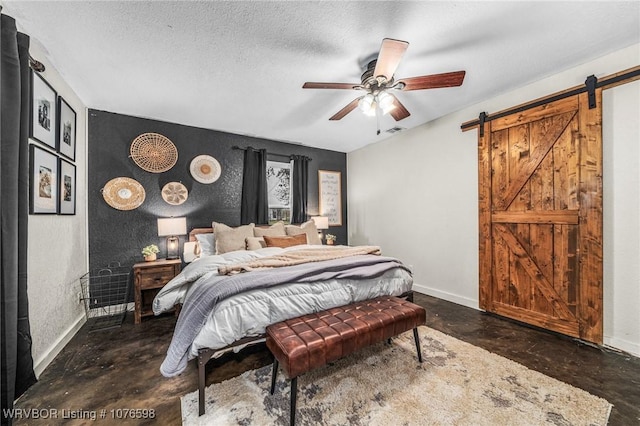 bedroom with a barn door, ceiling fan, and a textured ceiling