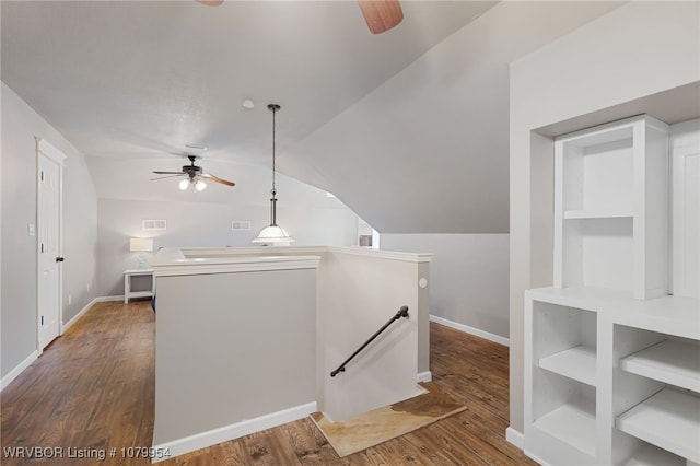 interior space featuring lofted ceiling, an upstairs landing, visible vents, baseboards, and wood finished floors