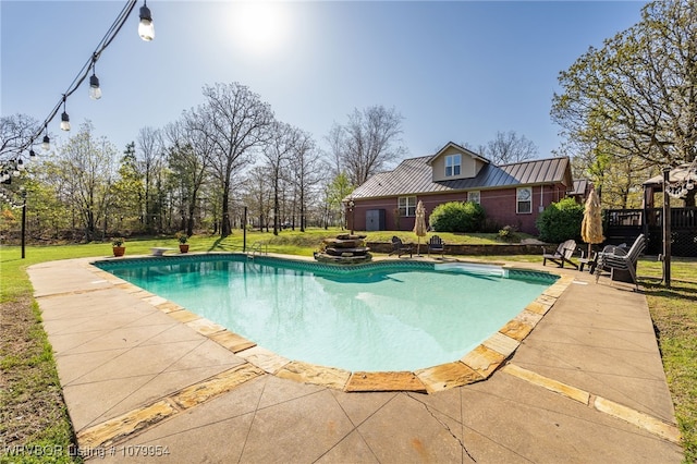 pool with a yard and a patio