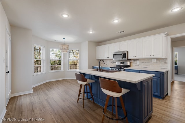 kitchen featuring a sink, white cabinets, appliances with stainless steel finishes, and visible vents