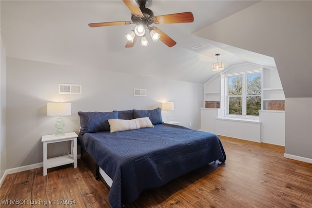 bedroom with visible vents, vaulted ceiling, and wood finished floors