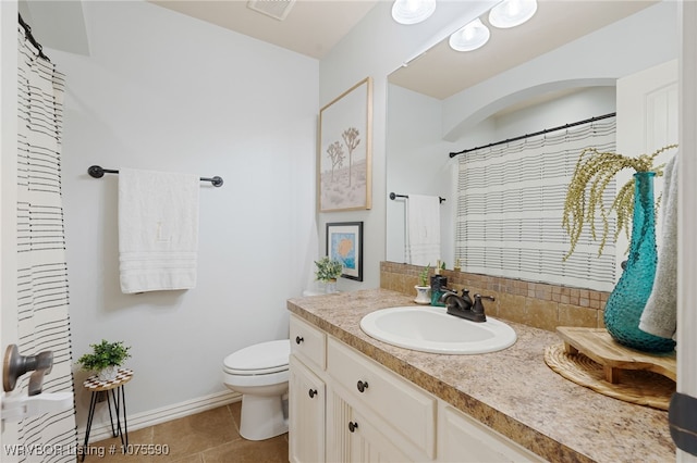 bathroom with tile patterned flooring, vanity, and toilet