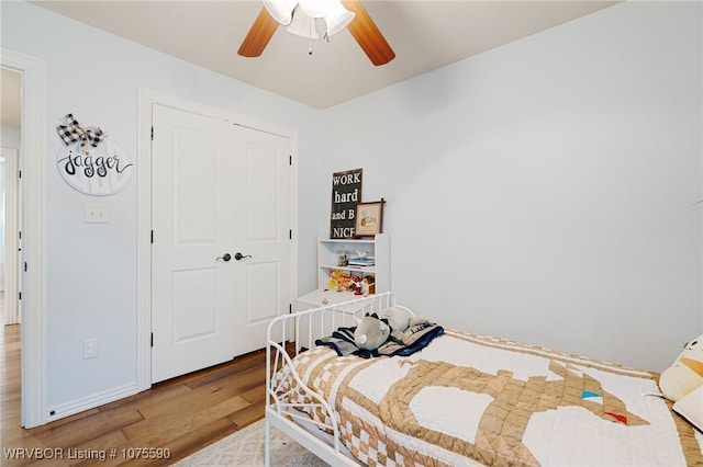 bedroom with hardwood / wood-style flooring, ceiling fan, and a closet