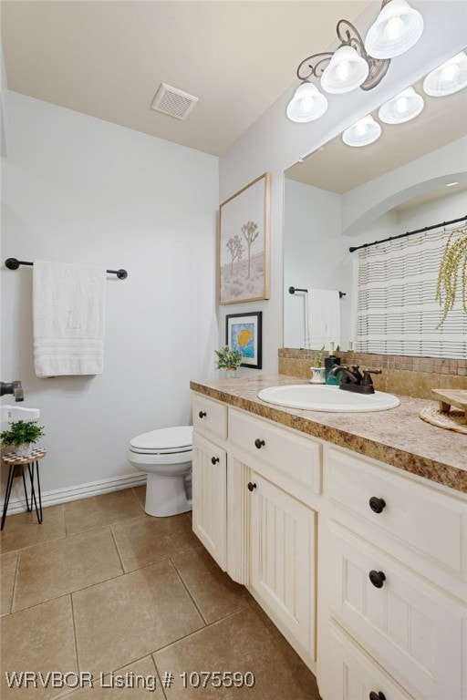 bathroom featuring tile patterned floors, vanity, curtained shower, and toilet