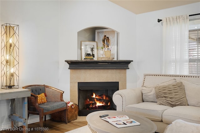 living room with hardwood / wood-style flooring and a tile fireplace