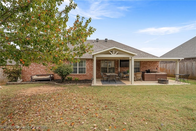 rear view of house with a lawn, a patio area, and an outdoor living space with a fire pit