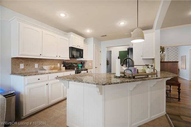 kitchen with backsplash, dark stone counters, decorative light fixtures, white cabinets, and black appliances