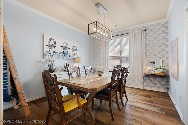 dining space with hardwood / wood-style floors, an inviting chandelier, and ornamental molding