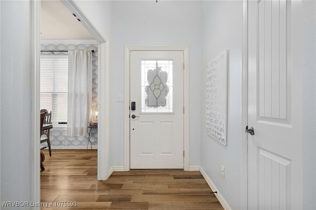 entrance foyer with crown molding and light hardwood / wood-style flooring