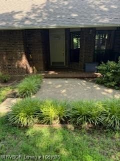 700 Timber Ridge Rd, Howe, OK 74937 - view of exterior entry with brick siding and a shingled roof