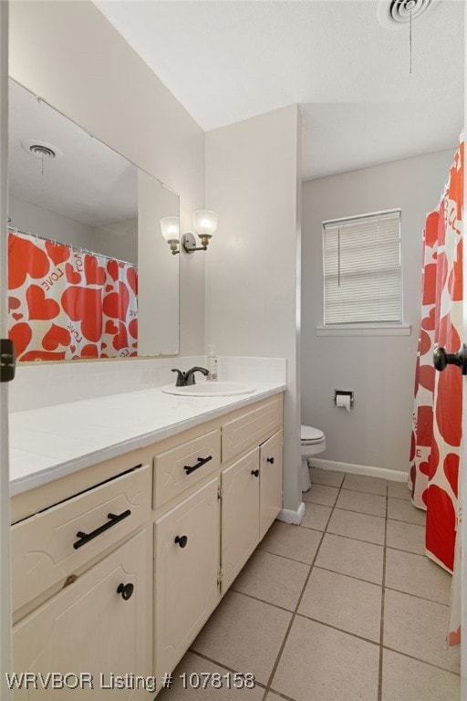 bathroom with tile patterned flooring, vanity, and toilet