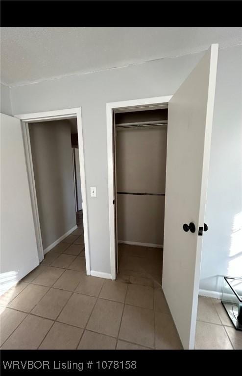 unfurnished bedroom featuring a closet and light tile patterned floors