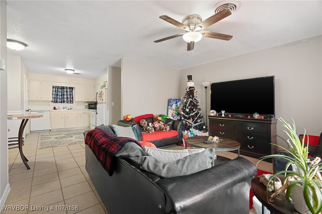 living room with light tile patterned floors, a textured ceiling, and ceiling fan